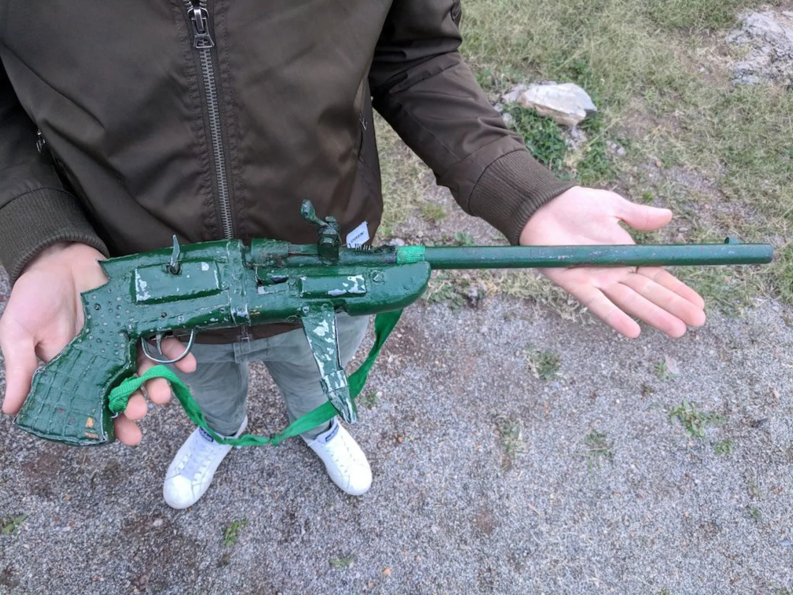 A self-made shotgun forged by poachers, bright green, with a trigger made from a Coca-Cola can